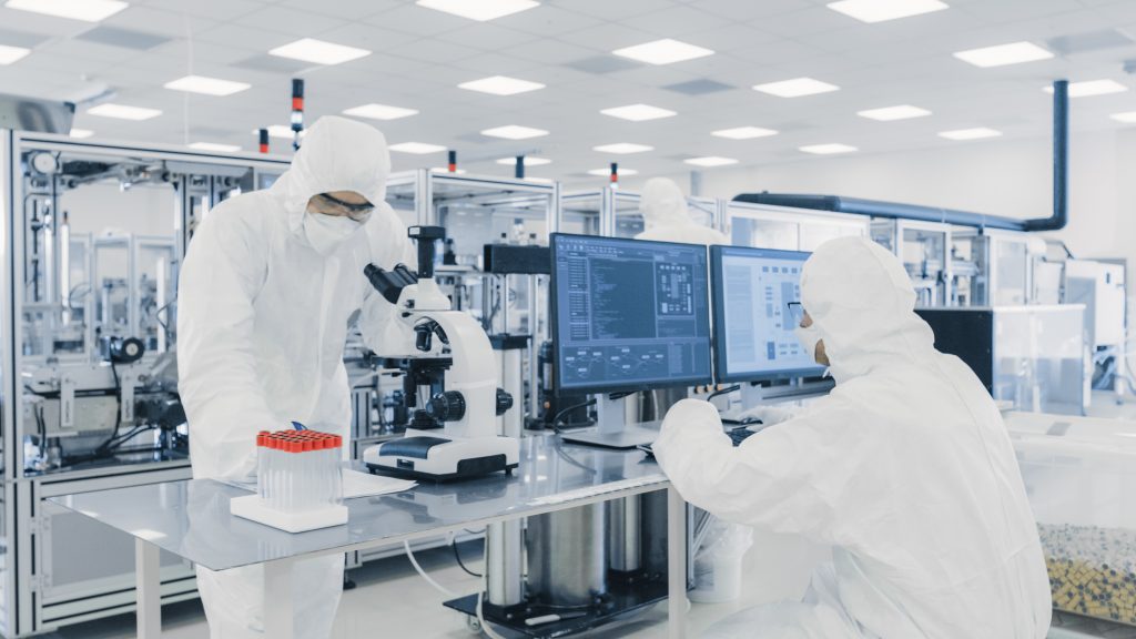Team,Of,Research,Scientists,In,Sterile,Suits,Working,With,Computers,