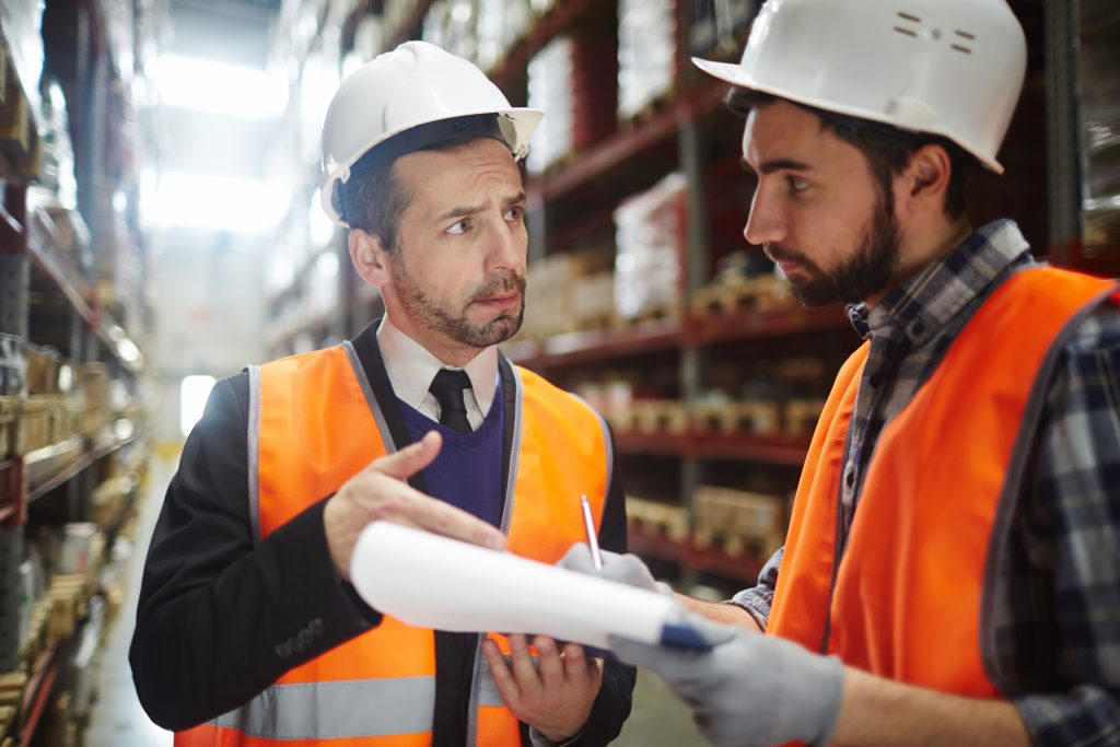 Portrait,Of,Warehouse,Worker,Talking,To,Supervising,Manager,While,Doing